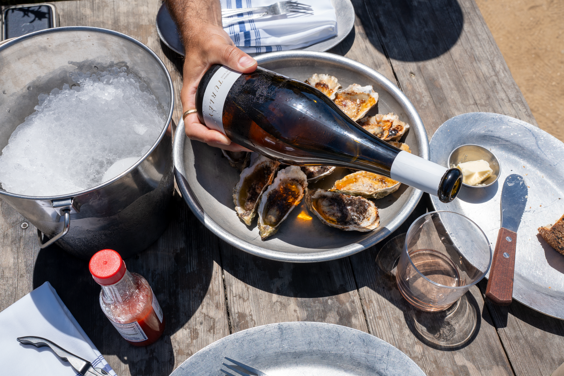 bottle of rose wine and oysters on a rustic wooden table